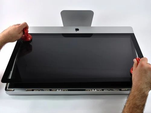 Technician repairing the screen of an Apple iMac in Dubai using professional tools